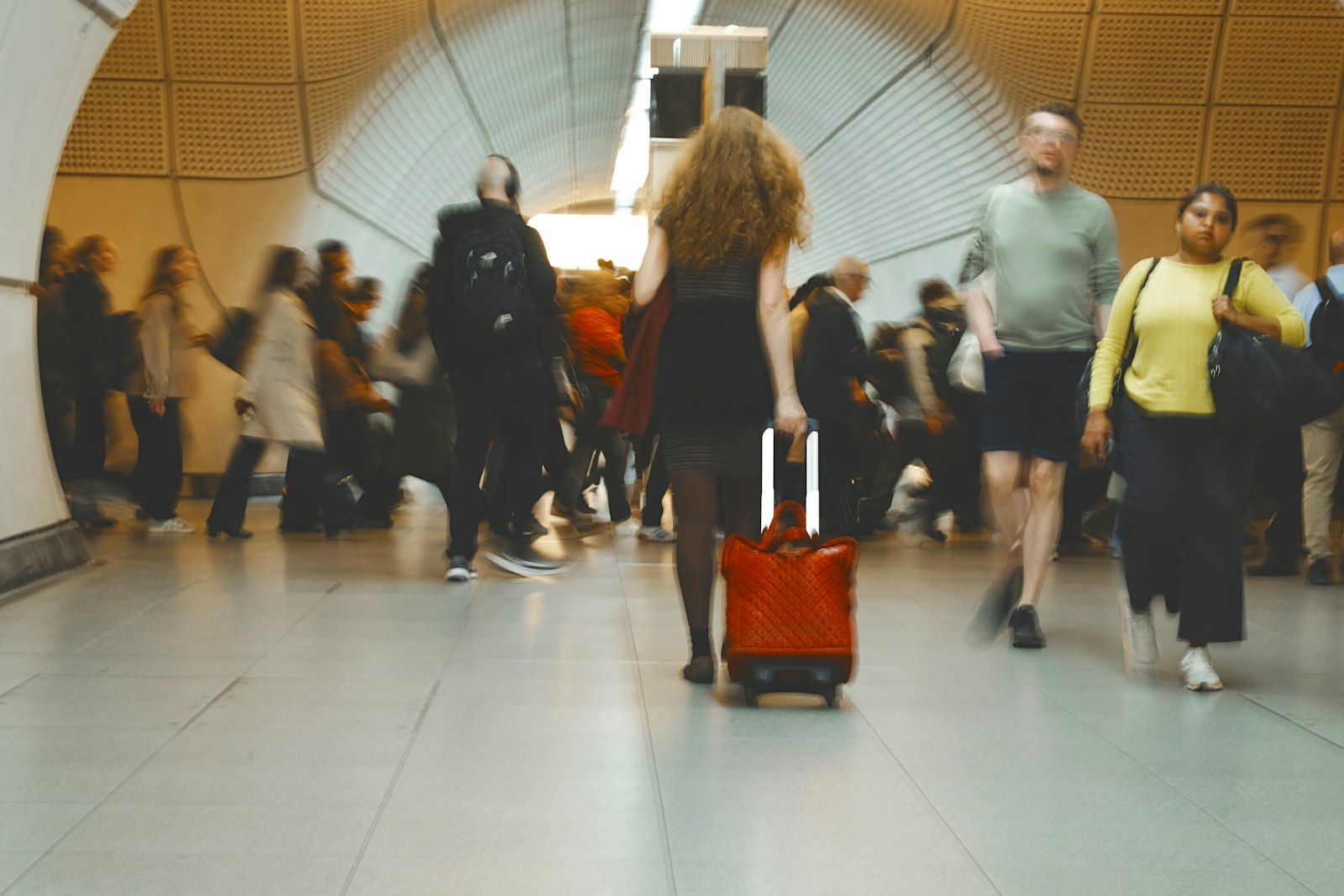 A traveler pulling a suitcase down station stairs